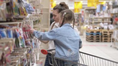 Gülümseyen Anne ve Çocuk Süpermarkette bir tramvayda oturuyor. Bir kız, annesinin bir hava balonu seçmesine yardım eder. Birlikte çok eğleniyorlar..