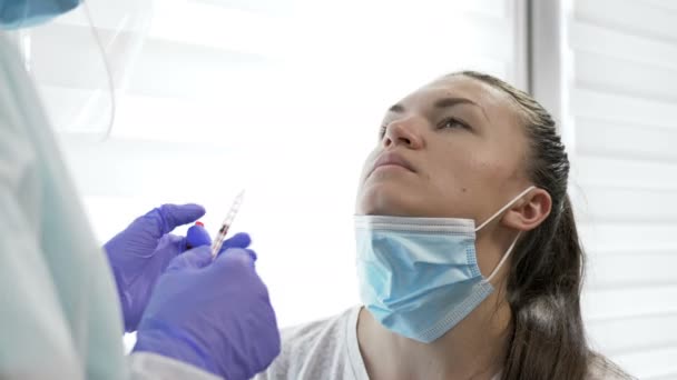 Vacunación nasal. El personal médico con traje protector administra una vacuna a través de la nariz a un paciente joven. Covid-19 . — Vídeos de Stock