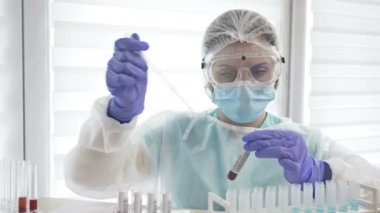 Laboratuvarda Coperid-19 için kan testi yapıldı. Dispanser ile çalışan kadın laboratuvar asistanı.