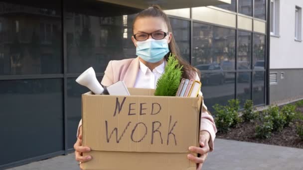 Donna d'affari in maschera medica in possesso di un segno bisogno di lavoro. Disoccupazione a seguito della pandemia del COVID-19 . — Video Stock