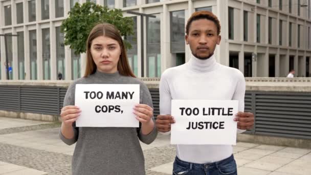 Farklı milletlerden erkek ve kız ırksal eşitsizliği protesto ediyor. Ellerinde de bir sürü polis ve çok az adli polis posterleri var.. — Stok video