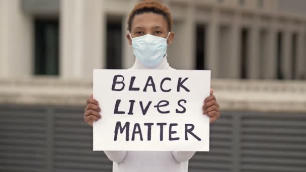 Плакат "ЧЕРНЫЙ ЖИЗНЬ" имеет значение в руках черного парня. Концепция "Остановить расизм" . — стоковое видео