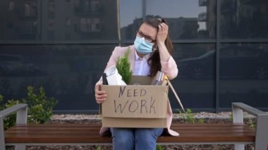 Genç bir kadın COVID-19 salgını sırasında ekonomik kriz nedeniyle işini kaybetti. Kişisel eşyalarının olduğu kutunun üzerinde çalışılması gerektiği yazıyor..