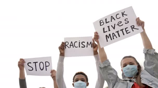 Tres jóvenes con máscaras médicas protestan contra la desigualdad racial. Tienen carteles en sus manos PARAR EL RACISMO Y LA MATERIA DE VIDA NEGRA . — Vídeo de stock