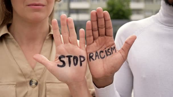 STOP RACISM napsaný na dlaních bílé dívky a černocha. Zastavit rasismus.