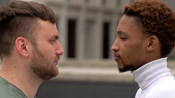 흑인 과 백인 남자는 서로를쳐다보고 있습니다. 다른 인종간의 관계와 연합에 대한 개념. — 비디오