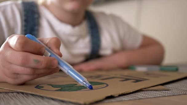 Schoolgirl makes a poster SAVE THE PLANET. — Stock Video