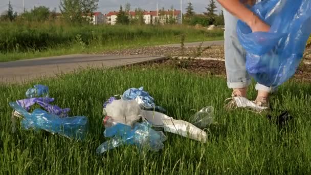 Vrijwilliger verzamelt afval in een blauwe zak. Tal van afval werd toegevoegd tijdens de COVID-19 pandemie. — Stockvideo