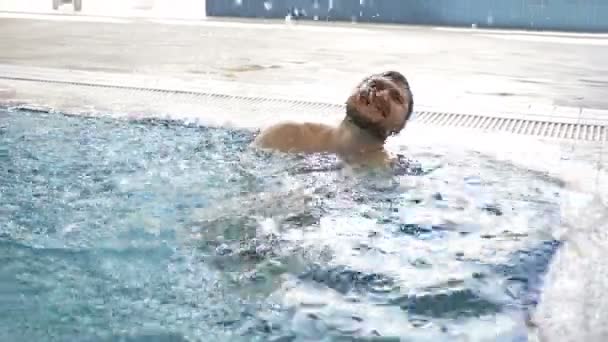 Alegre homem de meia-idade gosta de passar tempo na piscina interior . — Vídeo de Stock