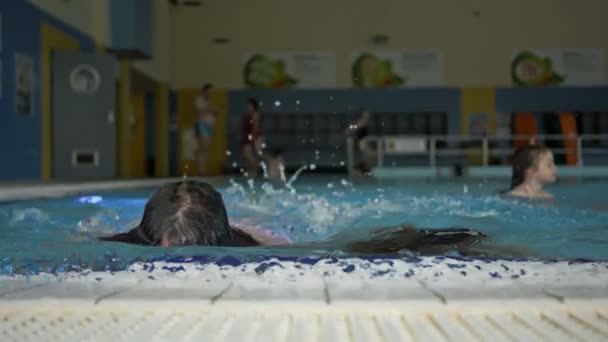 Dos alegres novias adolescentes emergen del agua de la piscina cubierta. Gran vista de las actividades al aire libre . — Vídeos de Stock