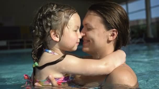 Ung kvinna med liten dotter ha kul i poolen. Mamma leker försiktigt med barnet. — Stockvideo