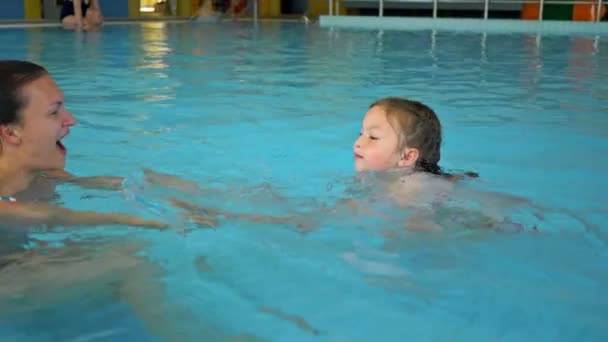 Молодая женщина учит плавать свою маленькую дочь . — стоковое видео
