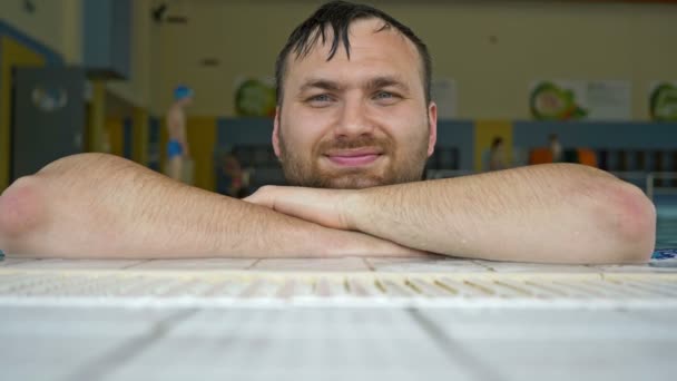 Retrato de un hombre alegre de mediana edad. Un hombre nadó en la piscina. Tiene la cara mojada, el pelo y una sonrisa contenta. . — Vídeos de Stock