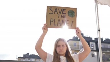 Ciddi genç kız elinde posteriyle Gezegeni Kurtarıyor.