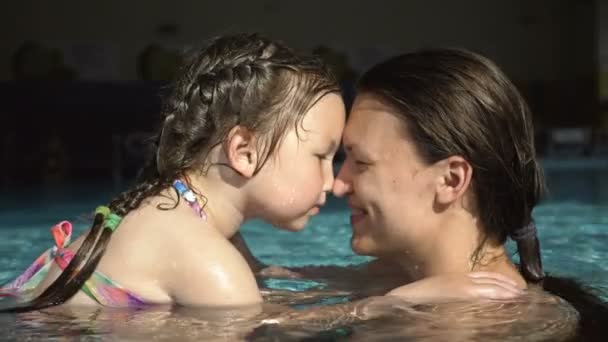 Jovem com filhinha se divirta na piscina. Mamãe gentilmente brinca com a criança . — Vídeo de Stock