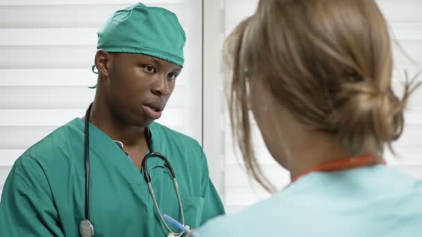 Νεαρός ειδικευόμενος Αφρικανός συμβουλεύεται έναν έμπειρο γιατρό. Η απουσία διαφυλετικών αντιθέσεων. — Αρχείο Βίντεο