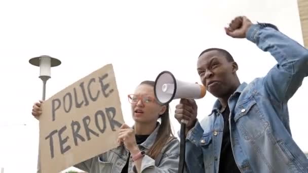 Rallie contra el racismo y la brutalidad policial. Chica con gafas ondeando una pancarta de TERROR POLICIAL. Junto con el negro están coreando consignas de protesta. BLM . — Vídeo de stock