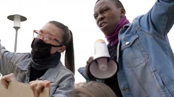 Protest tegen racisme. meisje met bril samen met de zwarte jongen ze zingen protest slogans. — Stockvideo