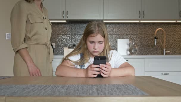 Maman est très en colère contre sa fille et la gronde. La fille est obstinément silencieuse et regarde l'écran d'un téléphone mobile. Ça agace encore plus maman. Difficultés à l'adolescence. — Video