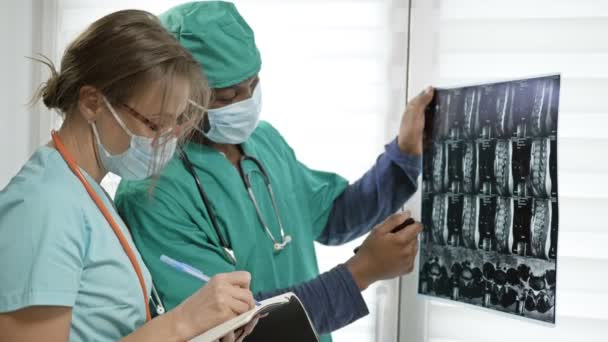 Молодой темнокожий врач дает указания медсестре. Концепция отсутствия межрасовых противоречий . — стоковое видео