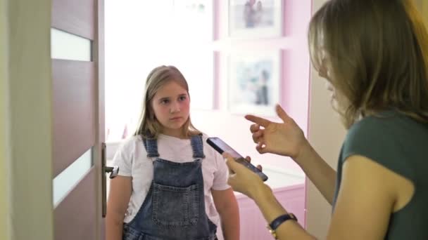 Problemas de parentalidade na família. Uma mulher repreende uma filha adolescente por alguma coisa. A menina desafiadoramente responde a sua mãe e fecha a porta na frente dela . — Vídeo de Stock