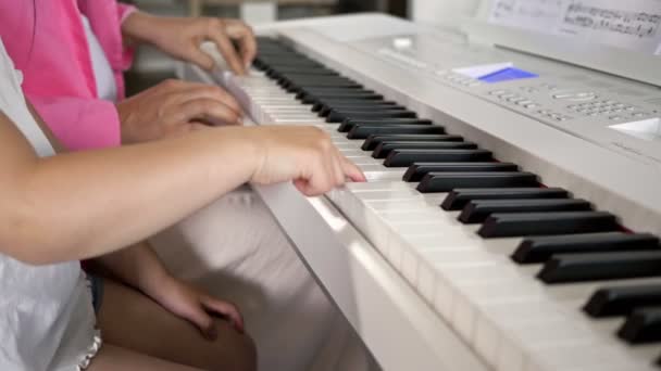 Privater Musiklehrer gibt Klavierunterricht für kleines Mädchen. Hände aus nächster Nähe. — Stockvideo
