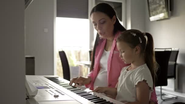 Вчитель піаніно дає урок маленькій дівчинці . — стокове відео