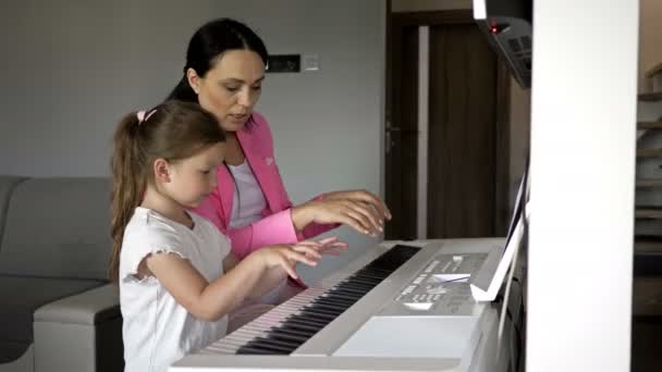 Professor de piano dando aula para uma menina . — Vídeo de Stock