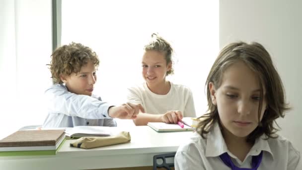 İki genç savunmasız sınıf arkadaşlarıyla alay ediyor. Çocuk zulmü. Okul zorbalığı. — Stok video