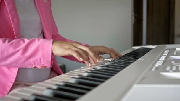 Jovem grávida joga em um piano digital branco para o bebê . — Vídeo de Stock