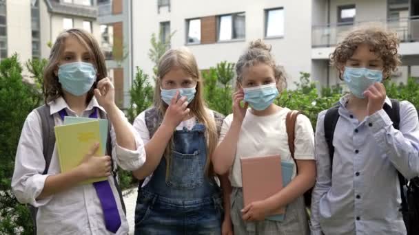 Schulkinder werfen Masken und verabschieden sich vom Covid-19 Coronavirus. Teenagergruppe freut sich über die Möglichkeit, keine lästigen medizinischen Masken zu tragen. — Stockvideo