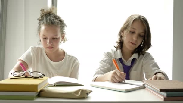 Os adolescentes escrevem um teste. Menina espreita em um caderno de colegas de classe . — Vídeo de Stock