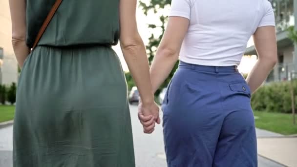 Twee lesbische meisjes houden elkaars hand vast. Romantisch afspraakje. LGBT-concept. — Stockvideo