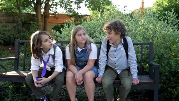 Drie schoolkinderen treiteren hun klasgenoot. Schoolpesten. — Stockvideo