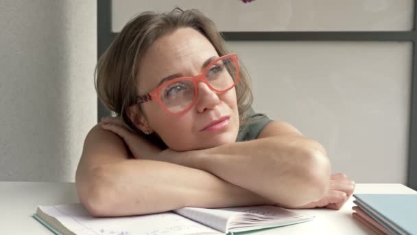 Professeure épuisée après une dure journée de travail. Elle se repose en étant assise à son bureau. — Video