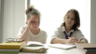 Öğrenci çocuk ve bir liseli kız sınıfta aynı masada oturuyorlar. Oğlan dikkatlice yazar, kız defterci çocuktan kurtulur..