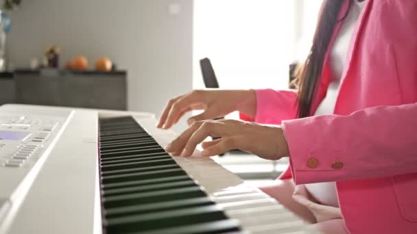 Giovane donna incinta suona su un pianoforte digitale bianco per il bambino. — Video Stock