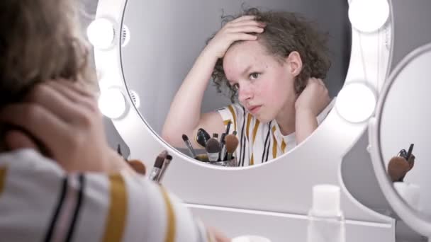 Εφηβικό κορίτσι συνθλίβει την ακμή, ενώ κοιτάζοντας στον καθρέφτη. — Αρχείο Βίντεο