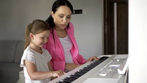 Piano teacher giving lesson to a little girl. — Stock Video