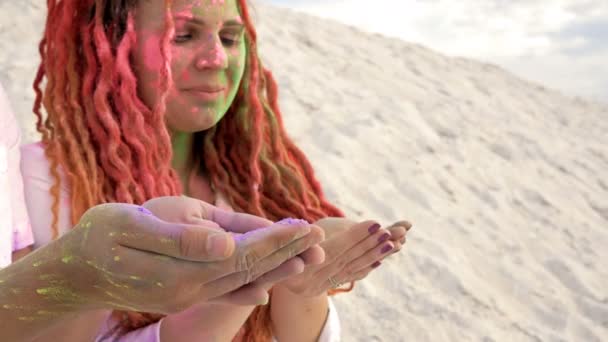 Unga par blåser ljust Holi-pulver ur handflatorna. Holi festivalen. Bra humör. — Stockvideo