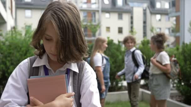 Een groep schoolkinderen bespot een klasgenoot. Wreedheid uit de kindertijd. Schoolpesten. — Stockvideo