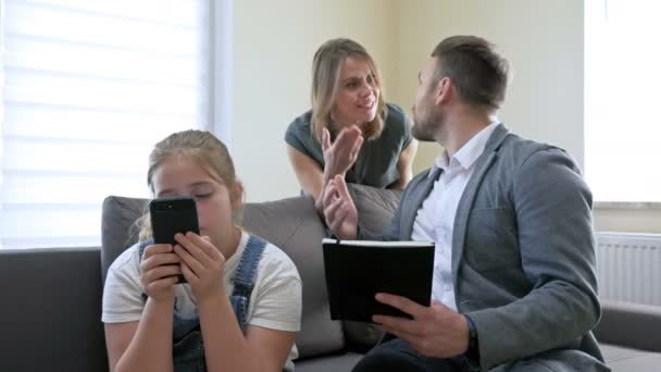家庭での子育ての問題。両親は十代の娘を何かのために非常に叱っている。女の子は電話の画面で無関心に見え、彼女の両親をさらに怒らせます. — ストック動画