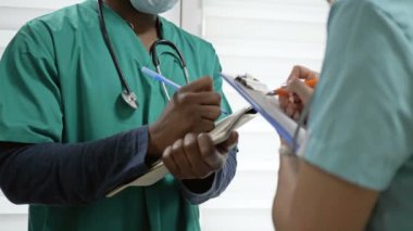 Koyu tenli doktor bir hemşireye yol gösterir. Irklar arası çelişkilerin yokluğu kavramı.