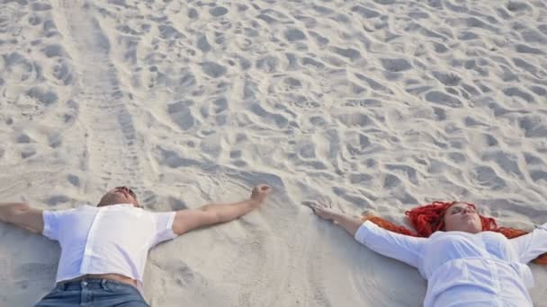 Couple romantique fabriquant des SAND ANGELS. Bonne humeur. — Video