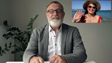 Neşeli yaşlı adam deniz kıyısında dinlenen genç bir kadınla video görüşmesi yapıyor. Çevrimiçi iletişim. Modern teknolojiler.