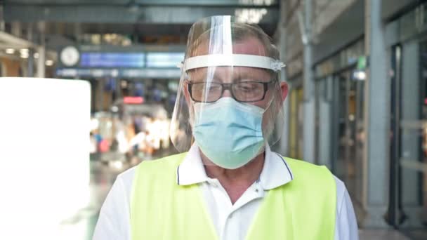 COVID-19 epidemie. Bij de stationsspecialist met een beschermend masker en handschoenen meet de temperatuur volgens een contactloze methode. — Stockvideo