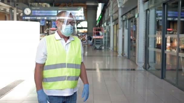 Medición de la temperatura sin contacto de los pasajeros en la estación. Especialista y pasajeros con máscaras protectoras. epidemia de COVID-19. — Vídeo de stock