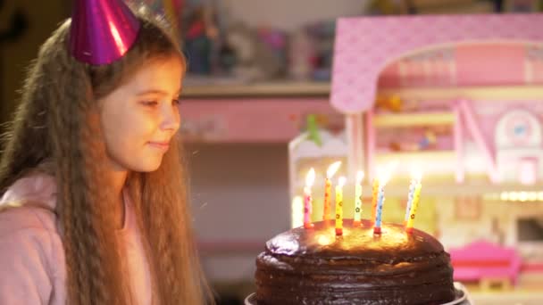 Ritratto di ragazza che soffia candele alla torta di compleanno al rallentatore. Primo piano del bambino che soffia fiamma di candela con desiderio — Video Stock