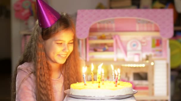 Πορτρέτο του χαρούμενου μικρού κοριτσιού που γιορτάζει τα γενέθλια του και φυσάει κεριά στην τούρτα. Έννοια διακοπών. — Αρχείο Βίντεο