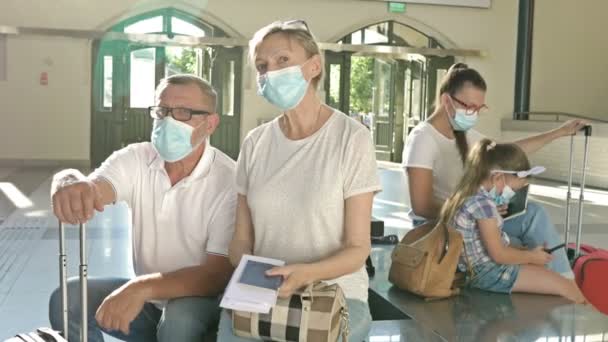 Pasażerowie czekają na swój lot w poczekalni. Każdy ma maski medyczne na twarzy. Podróże, turystyka podczas epidemii koronawirusów. — Wideo stockowe